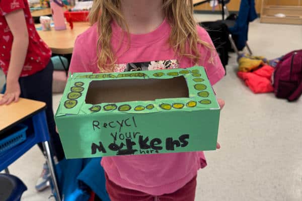Linsford Park PIF Project 2025 Linsford Park PIF Project 2025: A girl holds a marker collection box they decorated.